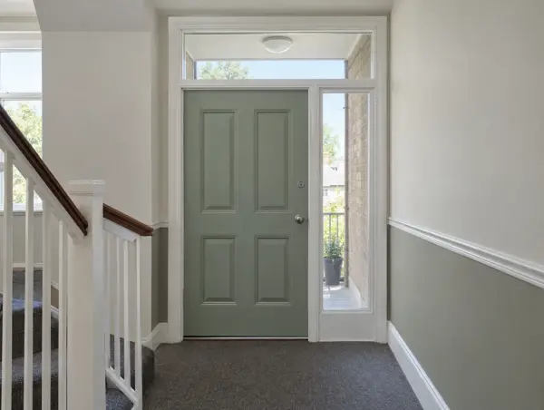 Communal hallway with a timber door, glazed fanlight above and glazed side panel